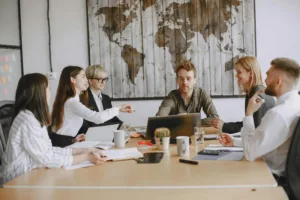 A group of HOA board members engaged in a collaborative meeting around a table, discussing agendas and best practices.